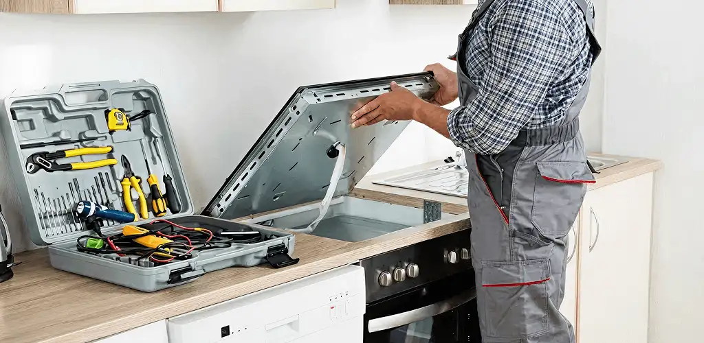Handyman repairing a cooktop and checking wiring connections in West Palm Beach, FL