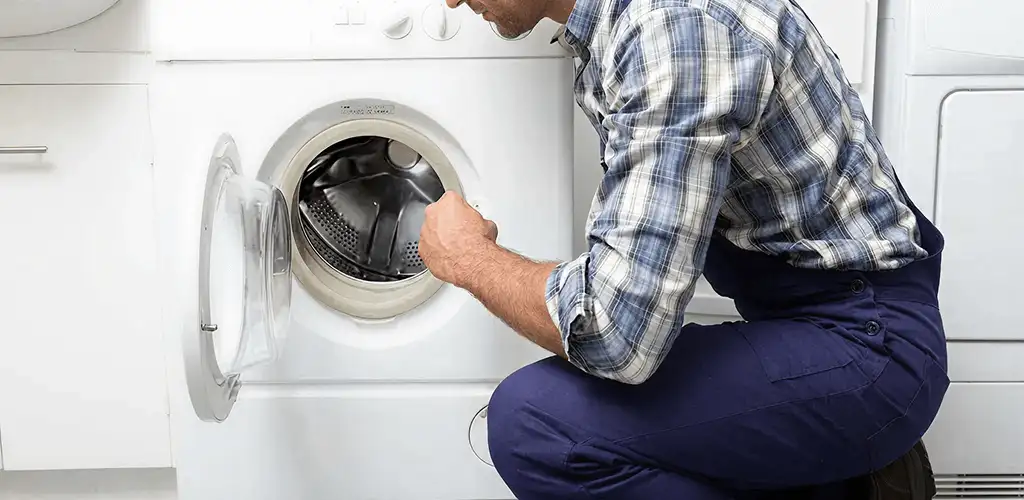 Handyman inspecting a dryer drum and internal parts for repair in West Palm Beach, FL