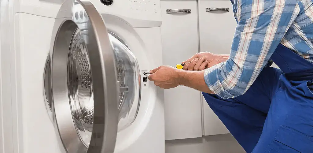 Handyman repairing a clothes dryer and checking electrical connections in West Palm Beach, FL