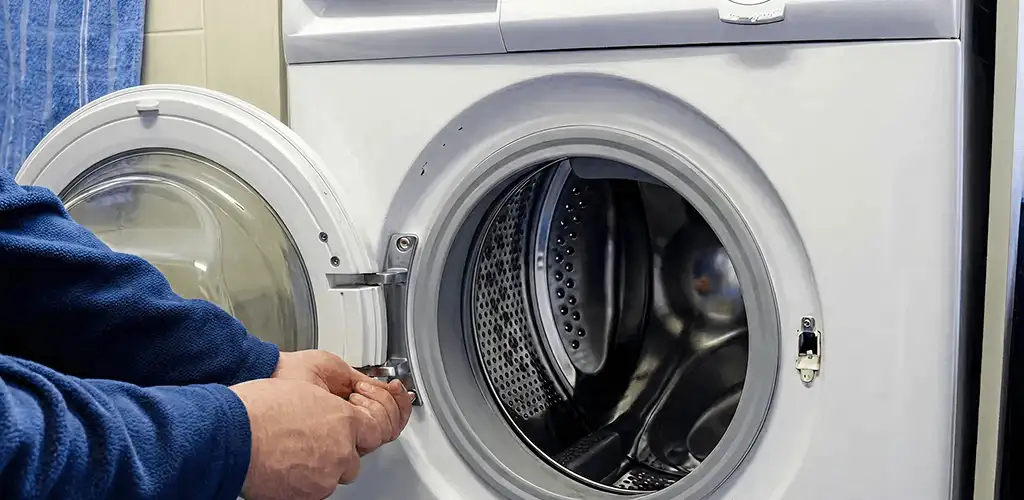 Washing machine repair handyman checking a front-load washer door and latch in West Palm Beach, FL
