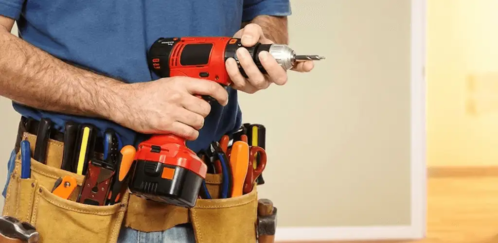 Handyman holding a power drill for home repairs and installations in West Palm Beach, FL