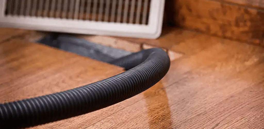 Air duct cleaning hose inserted into a floor vent for ductwork cleaning in West Palm Beach, FL