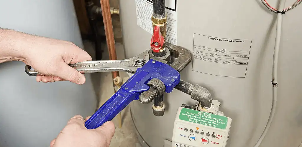 Water heater repair technician tightening the shutoff valve and supply line in West Palm Beach, FL