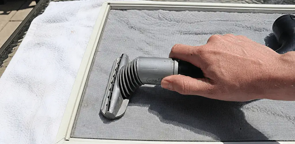 Window screen repair cleaning and fixing a damaged screen mesh in West Palm Beach, FL